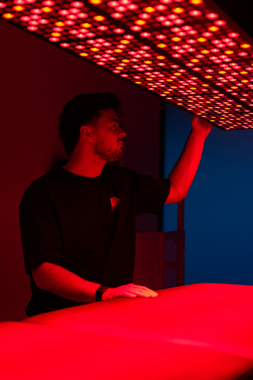 Herstelcoach Niels zet red light therapie toestel aan tijdens recovery behandeling